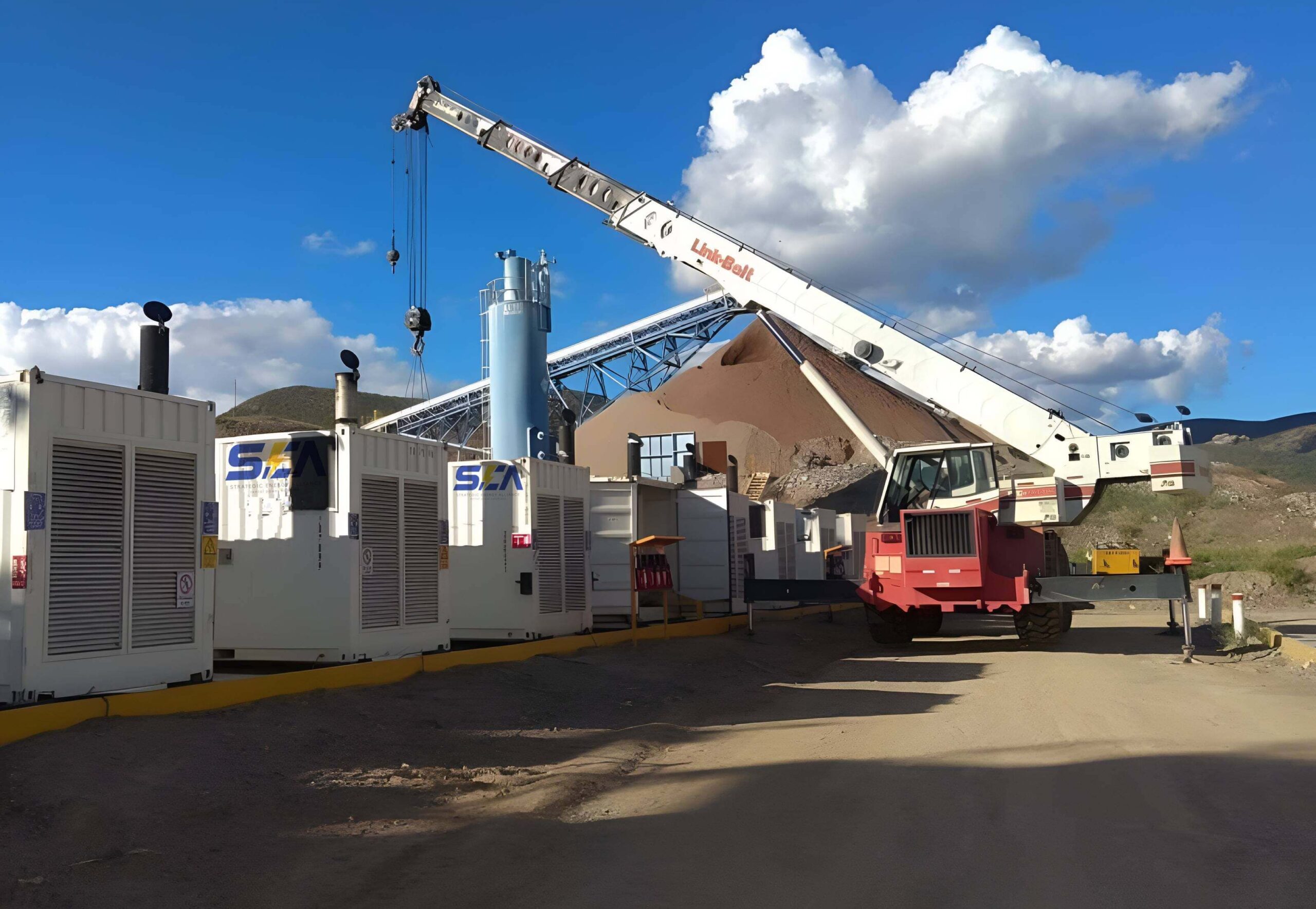 Grúa instalando Generadores de energía SEA en un sitio minero con montañas de material y cielo despejado